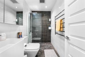 a white bathroom with a toilet and a shower at Waterfront North Wildwood Anglesea Family Retreat in North Wildwood +51 photos