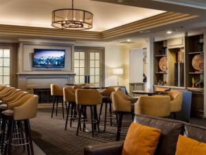 a bar with stools and a tv in a hotel room at Doubletree by Hilton, Leominster in Leominster