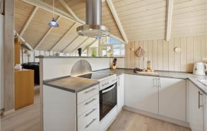 cocina con armarios blancos y fogones en Nice Home In Sydals With Sauna, en Skovby