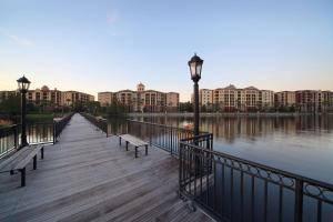 a wooden boardwalk next to a river with buildings at Hilton Grand Vacations Club Tuscany Village Orlando in Orlando