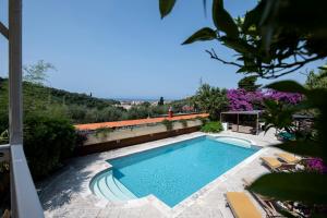 una piscina in un cortile con sedie e fiori di 201 - Appartamento in Villa, Giardino e Piscina Privata a Lavagna