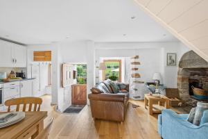 uma cozinha e sala de estar com um sofá e uma mesa em Middle Cottage - Tranquil cottage ideal for walkers em Cornworthy