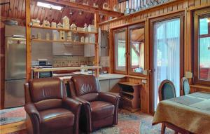 una cucina con due sedie in pelle e un tavolo in una stanza di 2 Bedroom Amazing Home In Wilcze a Wilcze