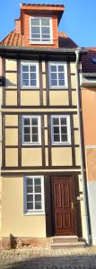 巴特弗蘭肯豪森的住宿－Schmal & Hoch - Willkommen im schmalsten Haus von Bad Frankenhausen，街上一扇棕色门的大房子