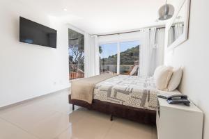 a bedroom with a bed and a large window at Hotel Ilha Branca Inn in Búzios
