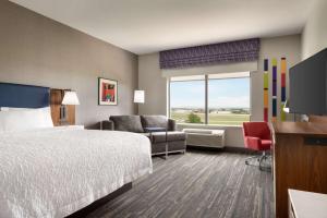 a hotel room with a bed and a flat screen tv at Hampton Inn & Suites Norman-Conference Center Area, Ok in Norman