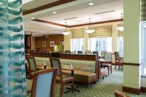a restaurant with tables and chairs and a bar at Hilton Garden Inn Seattle North/Everett in Mukilteo