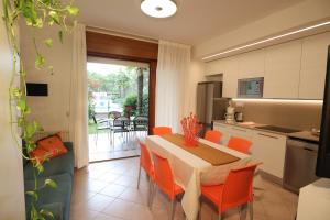 a kitchen and dining room with a table and chairs at Villaggio Mare Blu in Bibione