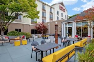 a patio at a hotel with tables and chairs at Hilton Garden Inn Portland/Beaverton in Beaverton