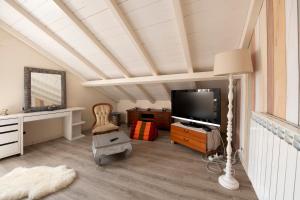 uma sala de estar com uma televisão de ecrã plano e uma cadeira em 201 - Appartamento in Villa, Giardino e Piscina Privata em Lavagna