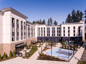 an exterior view of a building with a courtyard at Hilton Garden Inn Wilsonville Portland in Wilsonville