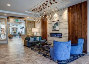 un salon avec des chaises bleues et une cheminée dans l'établissement Hilton Garden Inn Wilsonville Portland, à Wilsonville