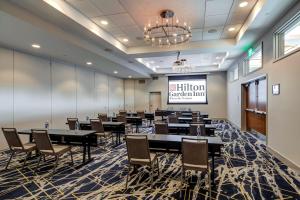 a conference room with tables and chairs and a projection screen at Hilton Garden Inn Wilsonville Portland in Wilsonville +36 photos