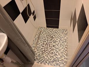 a bathroom with a shower with a tiled floor at Hôtel Beauséjour in Nevers