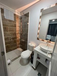 uma casa de banho com um WC, um lavatório e um chuveiro em El Oscar Hotel em Medellín