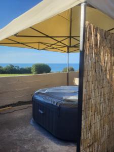 a bed under a tent with the ocean in the background at Ocean Retreat Norfolk in Trimingham