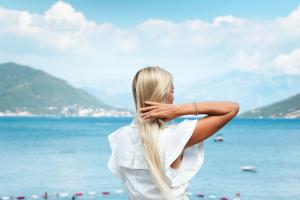 a woman standing on the beach with her long blonde hair at All'oro in Njivice