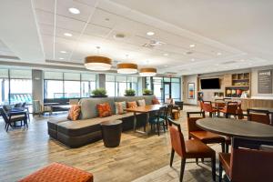 a lobby with a couch and tables and chairs at Home2 Suites By Hilton Pigeon Forge in Pigeon Forge
