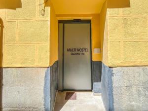 uma porta num edifício com um sinal em Multi Hostel Calvario em Madri