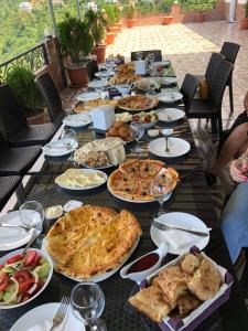 Goga Guest House في كفارياتي: طاولة طويلة عليها أطباق من الطعام