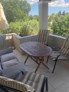 un patio con tavolo e sedie sul balcone. di Charieta n.8 ad Áno Korakiána
