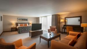 a hotel room with a bed and a living room at Clayton Hotel Dublin Airport in Cloghran