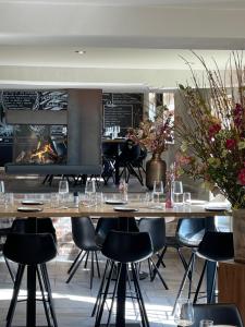 een restaurant met een tafel en stoelen en een open haard bij Harbourskitchenhouse@sea in Bredene