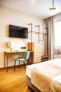 a hotel room with a bed and a desk and a chair at Villa Gran in Esztergom