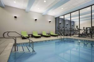 a swimming pool with green chairs in a building at Home2 Suites by Hilton Philadelphia Convention Center in Philadelphia
