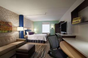 a hotel room with a bed and a couch at Home2 Suites by Hilton Philadelphia Convention Center in Philadelphia