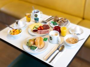 ハノーファーにあるB&B Hotel Hannover-Nordの朝食用の食材をテーブルに並べた朝食トレイ
