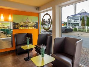 een wachtkamer in een restaurant met stoelen en tafels bij B&B Hotel Hannover-Nord in Hannover