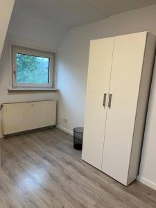 um quarto vazio com um grande armário branco e uma janela em Monteurwohnung in Kassel em Niestetal