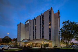 un bâtiment d'hôtel avec une voiture garée devant lui dans l'établissement DoubleTree by Hilton Philadelphia Airport, à Philadelphie