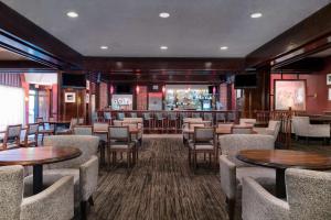un restaurante con mesas y sillas y un bar en DoubleTree by Hilton Philadelphia Airport, en Filadelfia