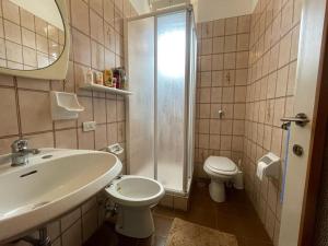 W łazience znajduje się umywalka, toaleta i prysznic. w obiekcie Margherita lake view Apartment w mieście Ispra