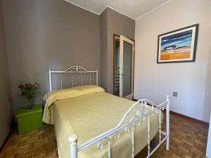 1 dormitorio con 1 cama blanca con manta amarilla en Margherita lake view Apartment, en Ispra