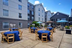 un patio al aire libre con mesas y sillas azules en Homewood Suites by Hilton Philadelphia-Great Valley, en Malvern