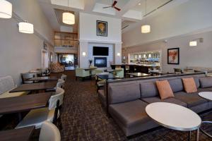 a hotel lobby with couches and tables and a restaurant at Homewood Suites by Hilton Philadelphia-Great Valley in Malvern