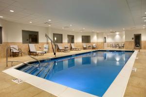 una piscina en una habitación de hotel con sillas y mesas en Hampton Inn Limerick, en Limerick