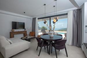 a living room with a table and a couch at Armante Supreme Villas - Villa Ilianna in Fternón