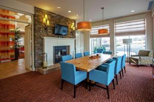 une salle à manger avec une table en bois et des chaises bleues dans l'établissement Hilton Garden Inn Valley Forge/Oaks, à Oaks