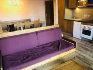a purple couch sitting in the middle of a kitchen at appartement Risoul 1850 résidence Deneb in Risoul