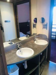un bagno con tre lavandini e un grande specchio di appartement Risoul 1850 résidence Deneb a Risoul