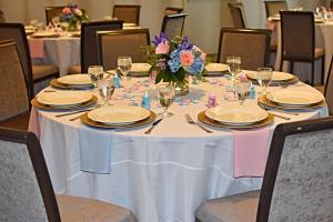 stół z talerzami, okularami i kwiatami w obiekcie Hilton Garden Inn Newtown Square Radnor w mieście Newtown Square