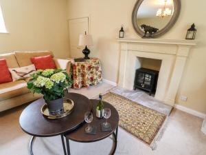 a living room with a table and a fireplace at Jasmine Cottage in Richmond