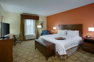 Hampton Inn & Suites Philadelphia/Bensalem في بنسالم: غرفه فندقيه سرير كبير وتلفزيون