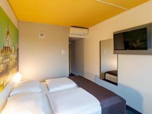 ハノーファーにあるB&B Hotel Hannover-Nordのベッドルーム(ベッド1台、薄型テレビ付)
