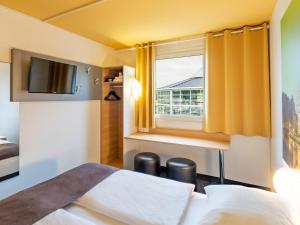 een hotelkamer met een bed en een raam bij B&B Hotel Hannover-Nord in Hannover