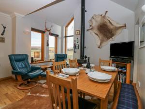 - une salle à manger avec une table et des chaises en bois dans l'établissement Otakaro, à Tomintoul